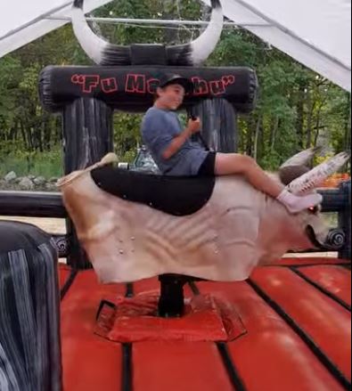 Boy sitting on Fu Manchu the mechanical bull