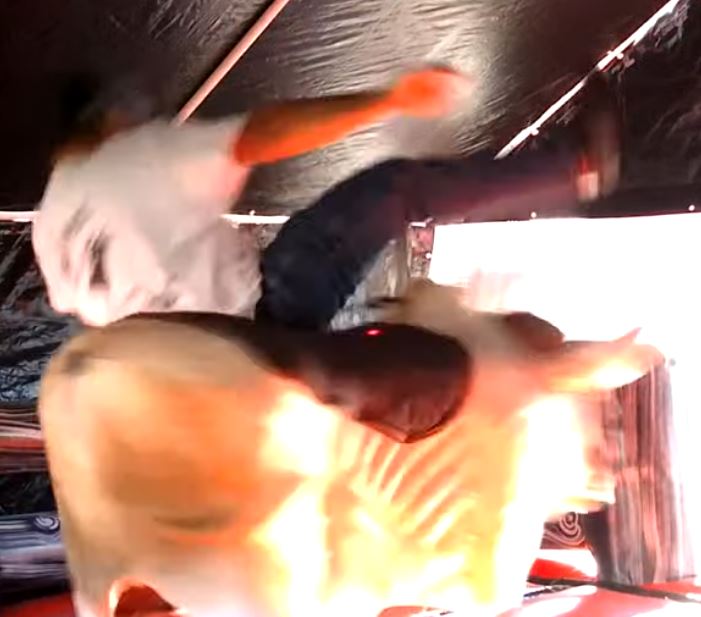 Man riding Fu Manchu the mechanical bull under the tent